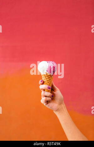 Woman's Hand Eis vor bunten Hintergrund Stockfoto