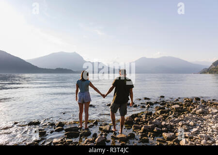 Junges Paar Hand in Hand am See Stockfoto