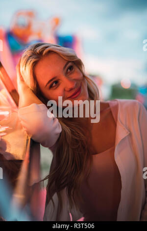 Portrait von lächelnden jungen Frau auf einer Kirmes Stockfoto