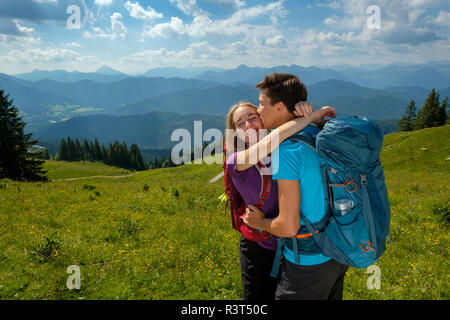 Deutschland, Bayern, in der Nähe von Lenggries, Brauneck glückliches junges Paar umarmen und küssen in der alpinen Landschaft Stockfoto