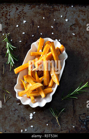 Süßkartoffel frites mit Rosmarin und Salz in Porzellan Schüssel Stockfoto