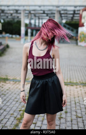 Junge Frau schüttelte ihre Haare gefärbt im Freien Stockfoto