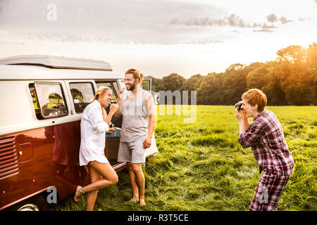 Frau sie Bilder von Freunden die Zähne putzen in einem Van in ländlichen Landschaft Stockfoto