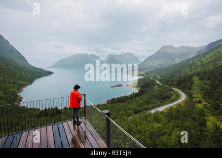 Norwegen, Insel Senja, Rückansicht der Mann stand auf einer Aussichtsplattform an der Küste Stockfoto