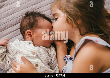 Liebevolle Mädchen liegt auf Decke Kuscheln mit Ihrem Baby Bruder Stockfoto