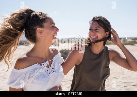 Freunde zu Fuß am Strand, im Gespräch Stockfoto