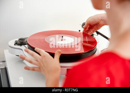 Frau, roten Vinyl Record auf Plattenspieler Stockfoto