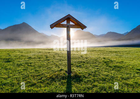 Deutschland, Bayern, Allgäu, Allgäuer Alpen, Loretto Wiese in der Nähe von Oberstdorf, Feld Kreuz gegen Morgen Sonne Stockfoto