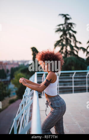 Porträt der nachdenkliche junge Frau auf der Terrasse am Abend dämmerung Stockfoto