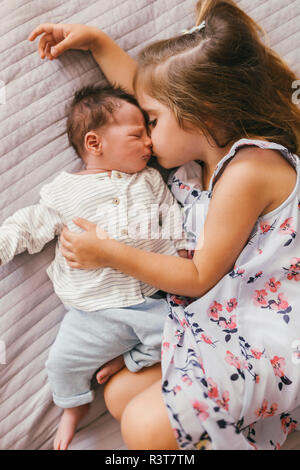 Liebevolle Mädchen liegt auf Decke Kuscheln mit Ihrem Baby Bruder Stockfoto