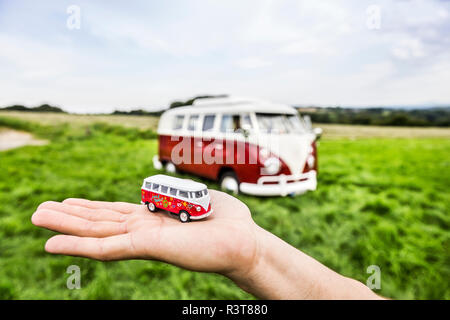 Hand woman holding van Modell neben van in ländlichen Landschaft Stockfoto