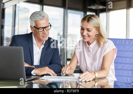 Geschäftsmann snd Frau sitzt im Büro, diskutieren Projekt Stockfoto