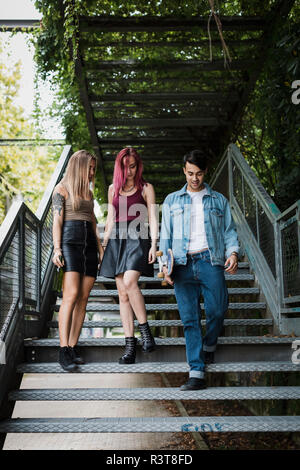 Freunde mit Skateboard zu Fuß auf der Treppe im Freien Stockfoto