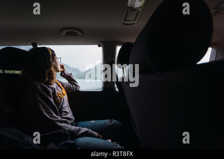 Norwegen, junge Frau in einem Auto Blick aus Fenster Stockfoto