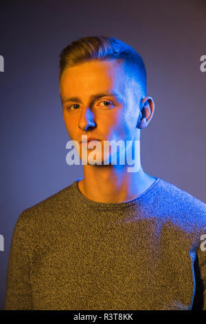 Portrait von ernsthaften jungen Mann im blauen Licht Stockfoto