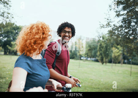 Freunde Wandern im Park, Reden, Frau, Fahrrad schieben Stockfoto