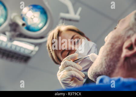 Zahnarzt bei chirurgischen Eingriffen auf einen Patienten Stockfoto