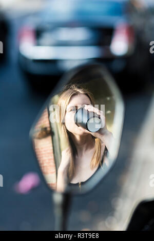 Junge Frau trinkt Kaffee, Spiegelbild Stockfoto