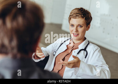 Ärztin im Gespräch mit Patienten in der Praxis Stockfoto