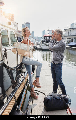 Ältere Menschen nehmen Bild der jungen Frau auf Steg neben Yachtcharter Stockfoto