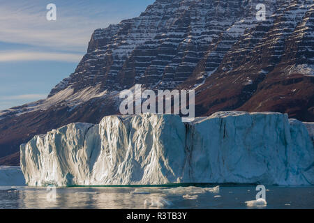 Grönland. Scoresby Sund. Gasefjord. Riesiger Eisberg und die Berge. Stockfoto
