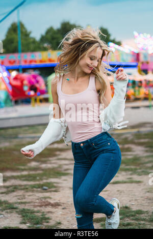 Glückliche junge Frau, die auf einem Jahrmarkt Stockfoto