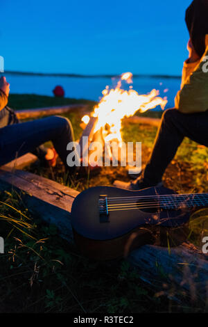 Freunde an einem Lagerfeuer sitzen und beobachtete die Flammen Stockfoto