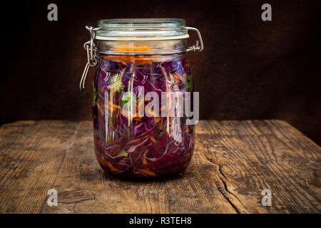 Hausgemachten Rotkohl, fermentiert, mit Chili, Karotte und Koriander, Einmachglas auf Holz Stockfoto