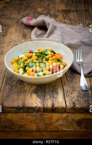 Kichererbsen Salat mit Kurkuma, geröstete Kichererbsen, Gurken, Tomaten und Petersilie Stockfoto