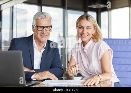 Geschäftsmann snd Frau sitzt im Büro, diskutieren Projekt Stockfoto