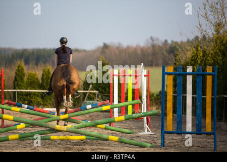 Junge Frau springen mit Pferd Stockfoto