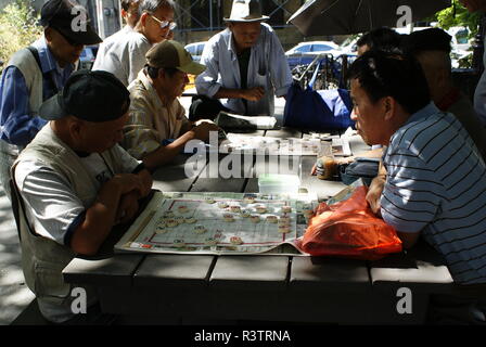 New York, USA - 5. Oktober 2018: Chinesische Männer spielen traditionelle Spiele in einem Park in New York. Stockfoto