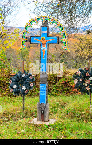 Maramures, Rumänien. In einem kleinen Aspra Dorffriedhof. Lackiertes Holz- Grabsteinen. Stockfoto