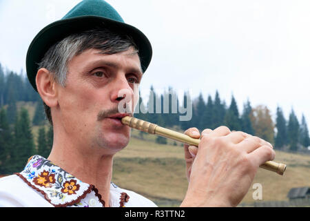 Rumänien. Moldovita. Dorf Musiker, Tänzer und Gönner der lokalen Cafe. Mann spielt Tin Whistle. Stockfoto