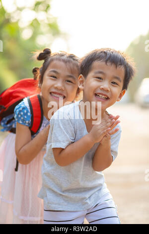 Freundliche asiatische Bruder und Schwester spielen mit Glück Emotionen im Freien Stockfoto