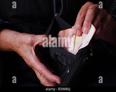 Die Frau Hände halten ein paar Euro Münzen. Pension, Armut, soziale Probleme und das Thema Alter. Speichern. Stockfoto