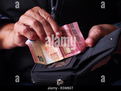 Die Frau Hände halten ein paar Euro Münzen. Pension, Armut, soziale Probleme und das Thema Alter. Speichern. Stockfoto