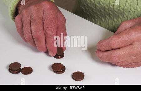 Die Frau Hände halten ein paar Euro Münzen. Pension, Armut, soziale Probleme und das Thema Alter. Speichern. Stockfoto