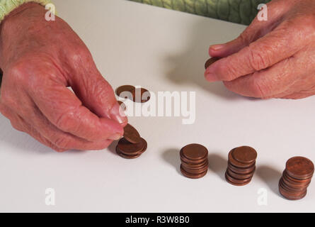 Die Frau Hände halten ein paar Euro Münzen. Pension, Armut, soziale Probleme und das Thema Alter. Speichern. Stockfoto