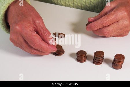 Die Frau Hände halten ein paar Euro Münzen. Pension, Armut, soziale Probleme und das Thema Alter. Speichern. Stockfoto