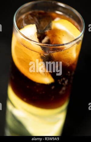 Cuba Libre Cocktail mit Rum, Cola und Limettensaft mit Kalk Keil und voll von Ices mit isolierten schwarzen Hintergrund Stockfoto