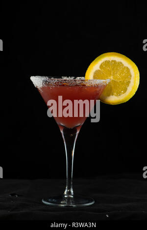 Cosmopolitan Cocktail mit Cranberry Saft, Wodka, Limettensaft und Cointreau mit isolierten schwarzen Hintergrund Stockfoto