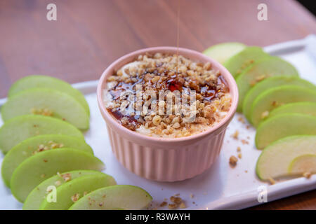 Caramel Apple Dip mit Muttern, Karamell Dressing und frische Apfelscheiben auf Holz Stockfoto