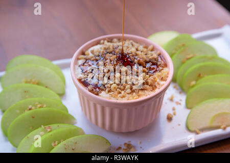 Caramel Apple Dip mit Muttern, Karamell Dressing und frische Apfelscheiben auf Holz Stockfoto