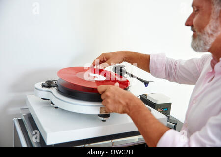 Reifer Mann, roten Vinyl Record auf Plattenspieler Stockfoto