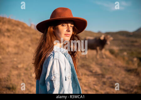 Porträt der jungen Frau mit Hut in ländlichen Landschaft Stockfoto
