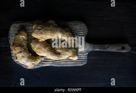 Rohen Ingwer Wurzeln auf vintage Holz Schneidebrett mit Kopie Raum Stockfoto