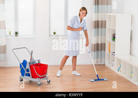 Weibliche Haushälterin Reinigung Boden mit Mop Stockfoto