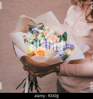 Bunten Strauß von verschiedenen frischen Blumen in der Hand von Floristen Frau. Rustikale Blume Hintergrund. Handwerk Blumenstrauß. Stockfoto