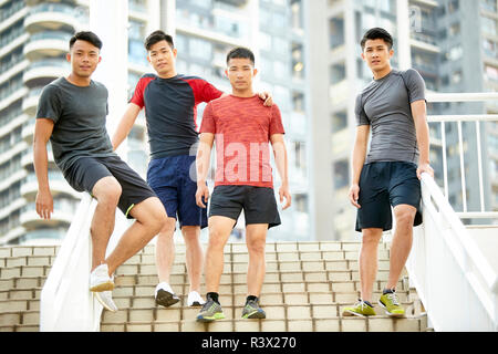 Outdoor Portrait von einem Team von vier asiatischen jungen Athleten auf Schritte Stockfoto